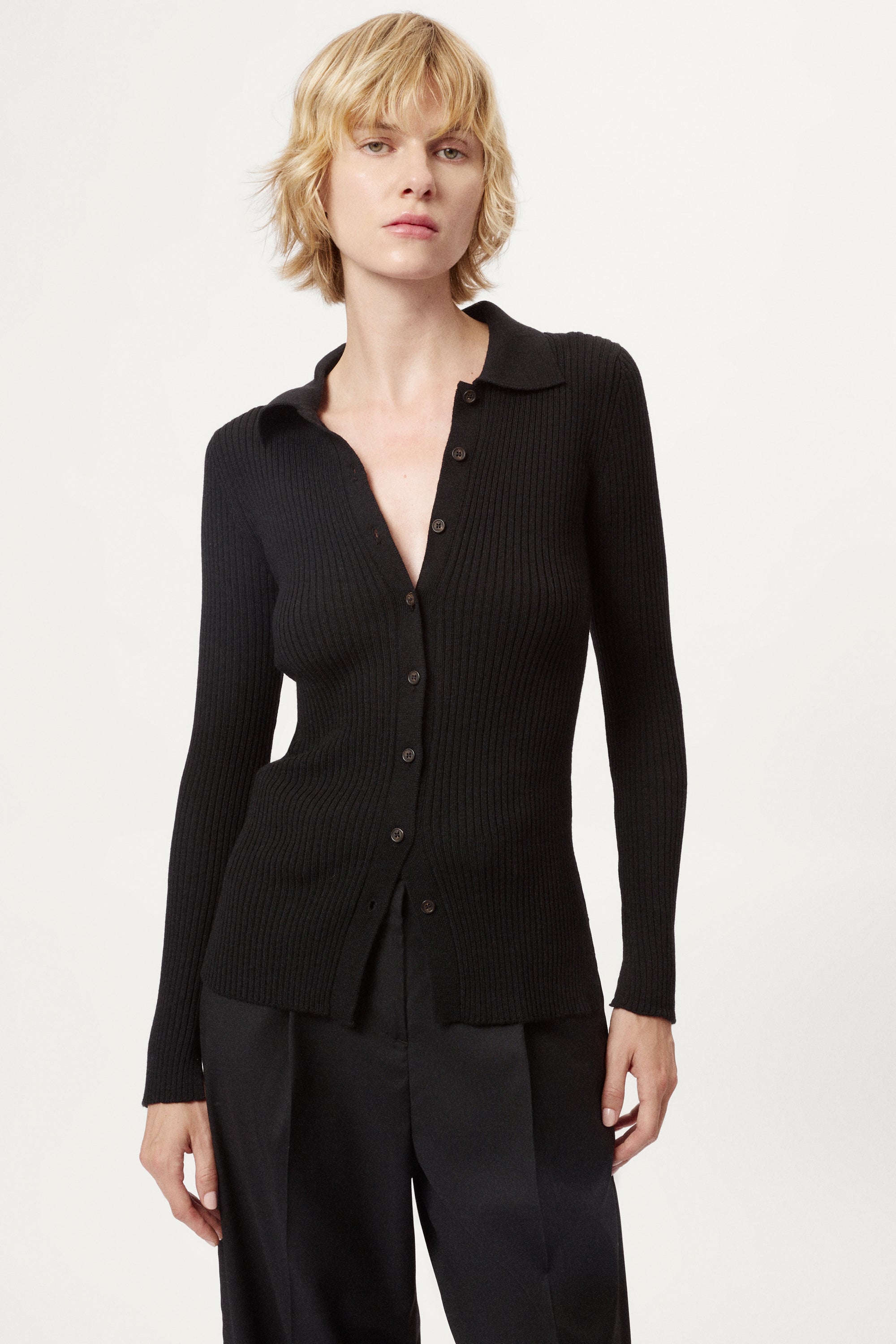 Woman wearing a black ribbed merino shirt on a white background