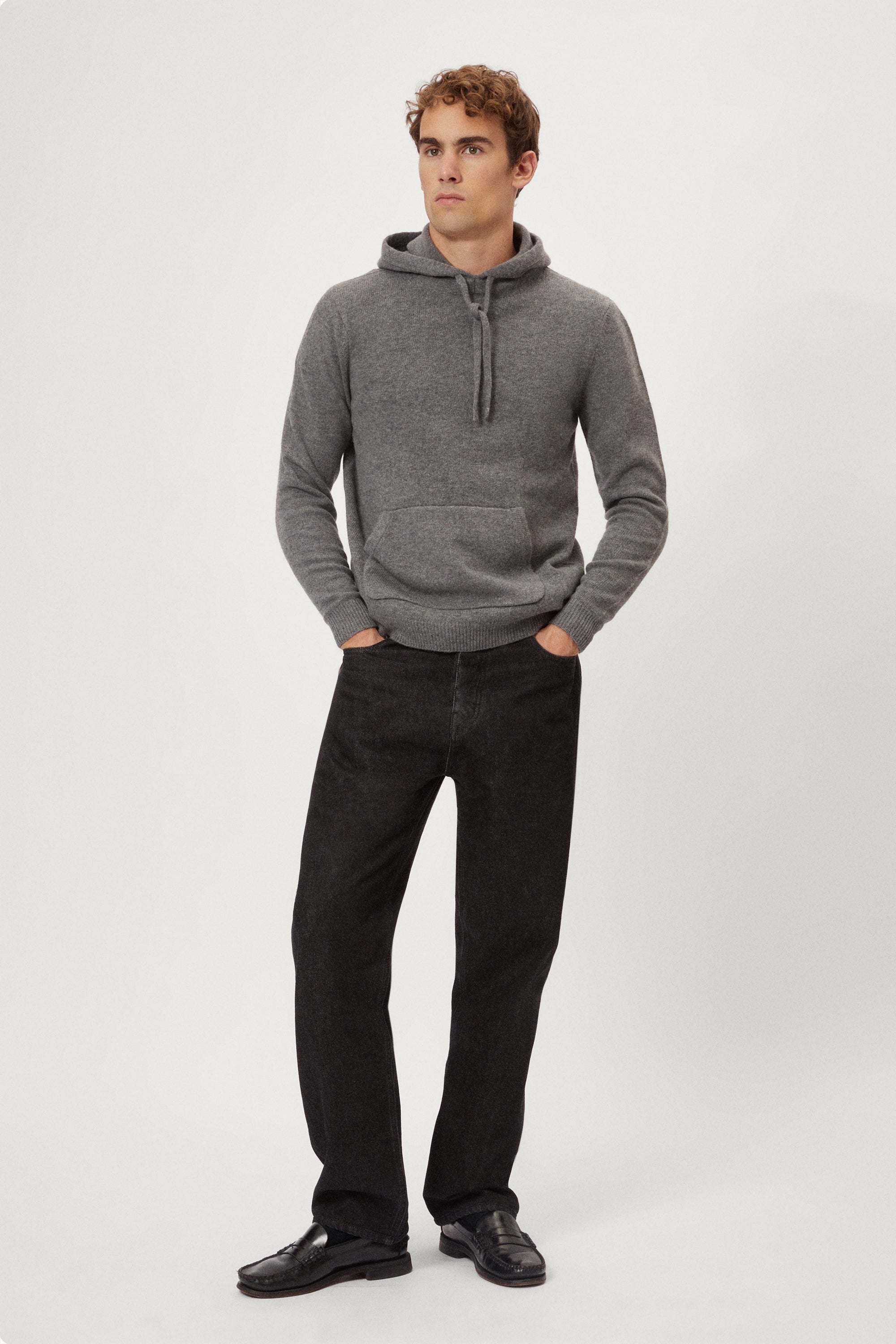 Man wearing a light gray woolen hoodie on a white background