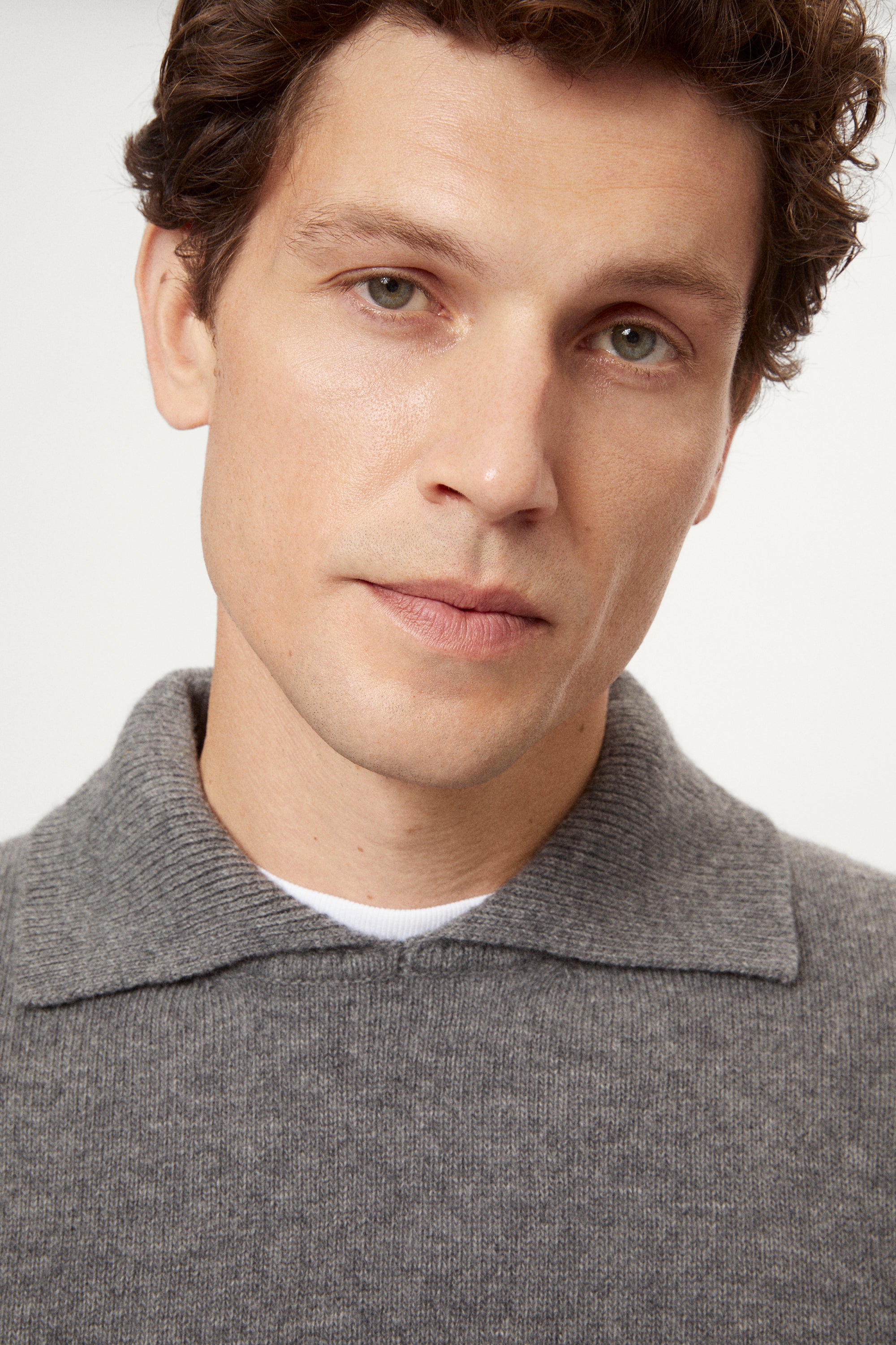 Man wearing a gray woolen polo sweater