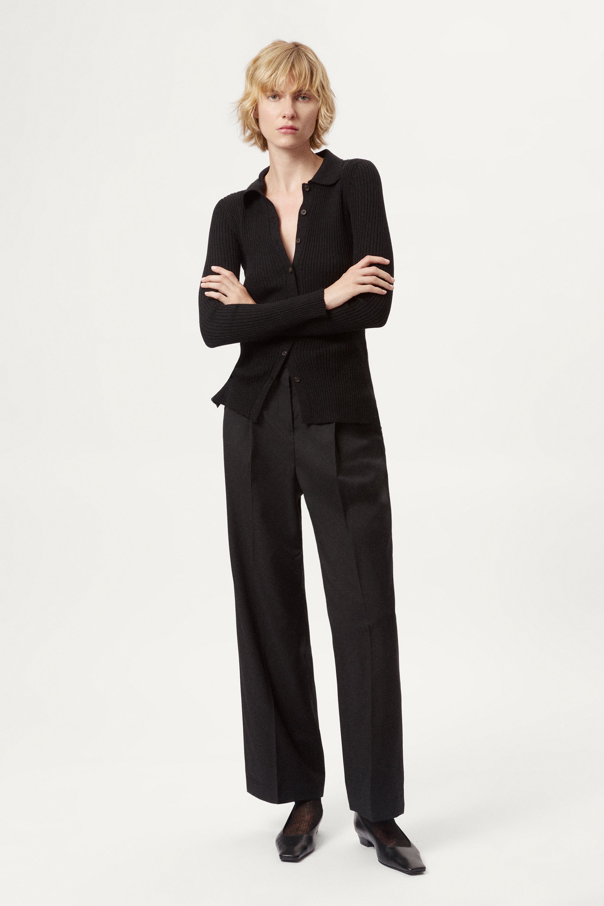 Woman wearing a black ribbed merino shirt  on a white background